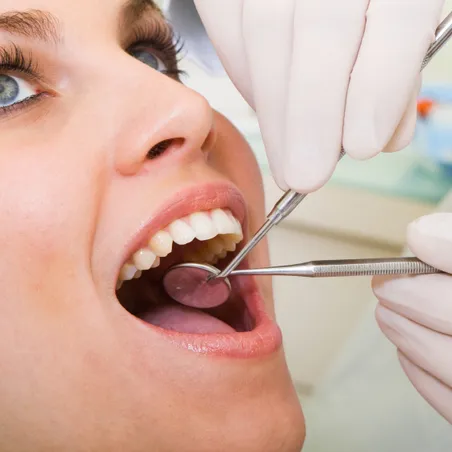 dentist examining inside woman's mouth