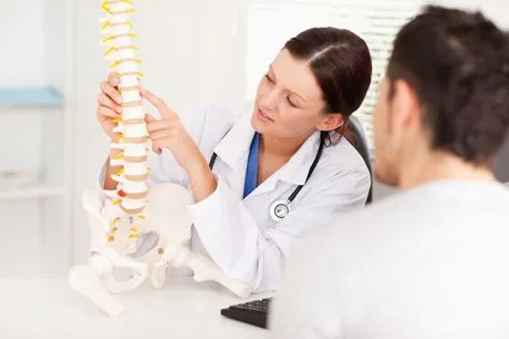 doctor showing spine model to a patient