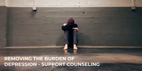 photo of a person sitting on the floor with head on knees with words over top that says removing the burden of depression