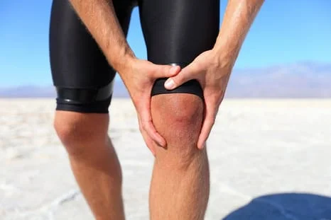 A male holding his knee