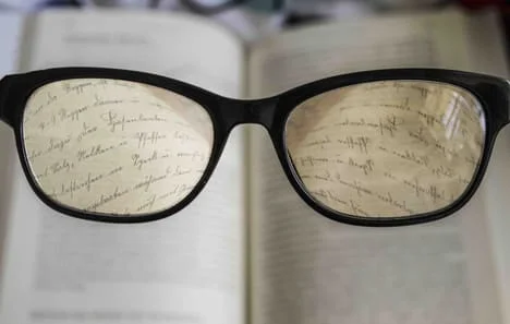 Eye glasses with book behind