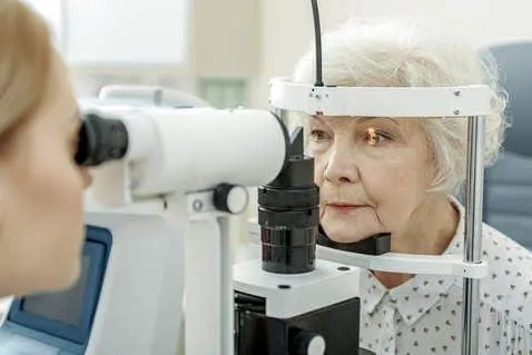 doctor doing dry eye evaluation on older lady