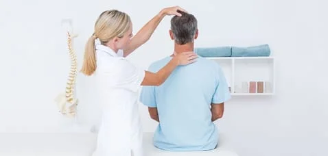 chiropractor gives patient an adjustment on his neck after an auto accident