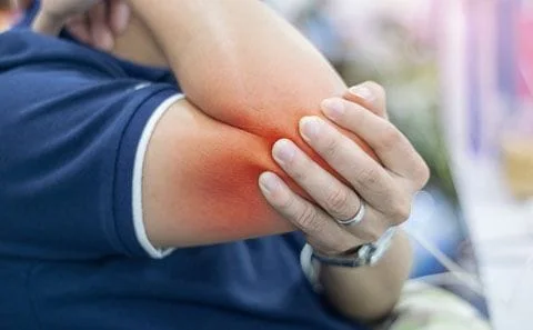 Person holding elbow in pain
