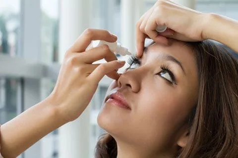 Young women using eye drops