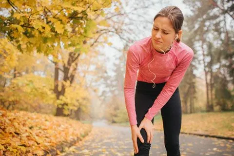 Women holding knee in pain