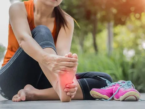 Women holding foot in pain