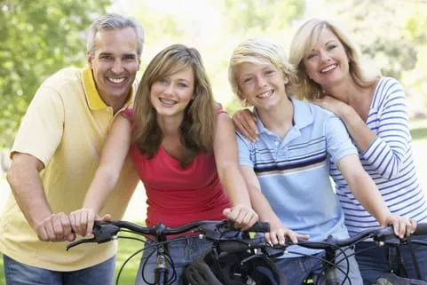 Family smiling while riding bicycles