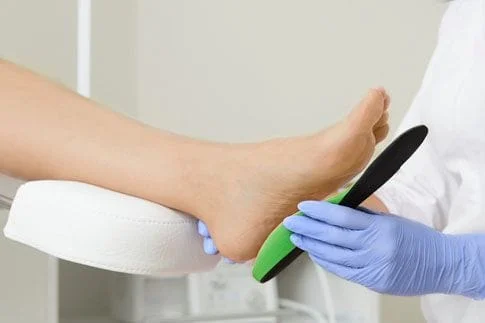 Doctor fitting a foot with orthodics