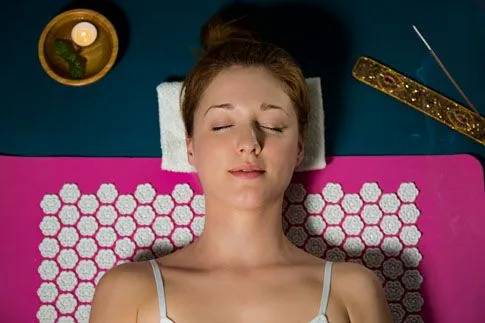 Women laying on acupuncture mat