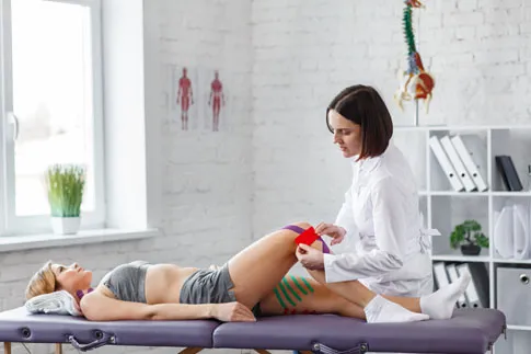 Women having kinseio tape placed on knees