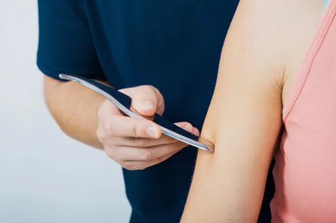 Women having arm treated with tool