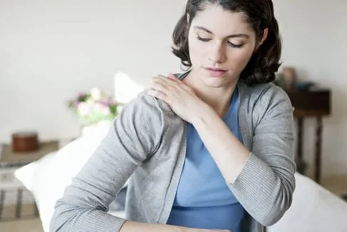 woman enduring shoulder pain
