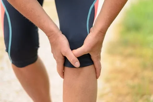 Women holding knee in pain