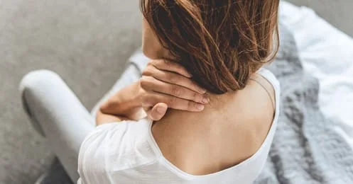 woman holding neck in pain