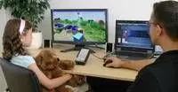 young girl with therapist sitting in front of computer