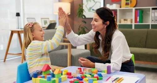 Woman playing to a young girl giving highfive