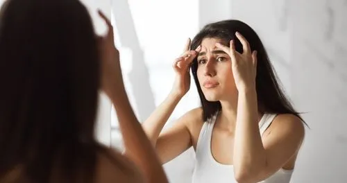 Woman worry looking in mirror with wrinkles