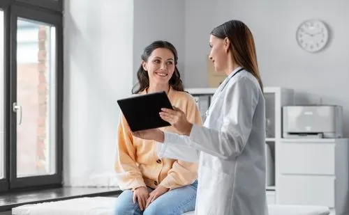 Young woman consult with the doctor while sitting on clinical bed.