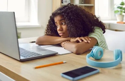 Black young boy bored while looking in the computer