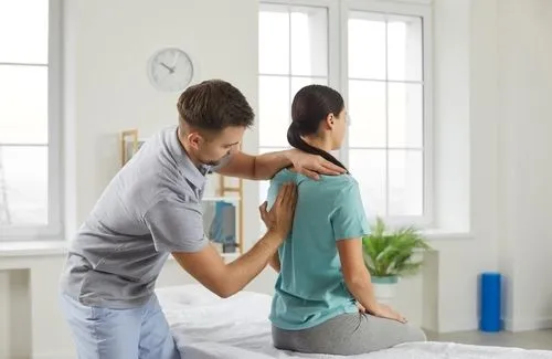 Female patient undergoing back adjustment by chiropractor.