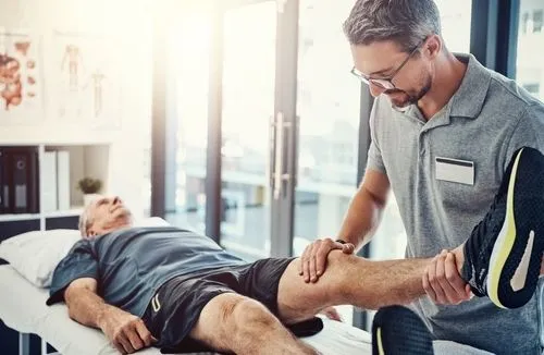 Chiropractor treating knee pain in a senior client