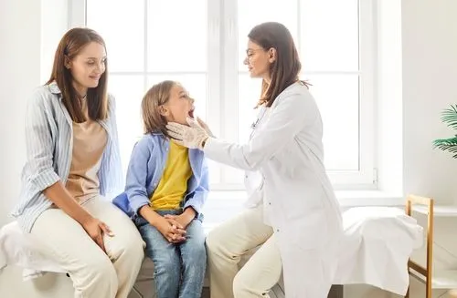 Child being assessed for strep throat by a pediatrician