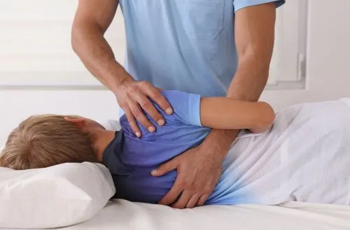 Chiropractor performing adjustment to improve child’s posture.