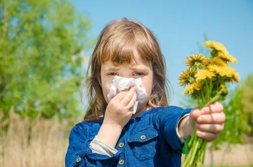Child suffering from allergic reaction triggered by a flower.