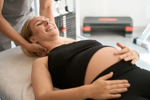 Pregnant woman during a chiropractic session with her provider.