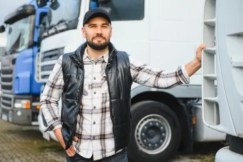 A man smiling beside his truck after successfully passing his Department of Transportation (DOT) exam.
