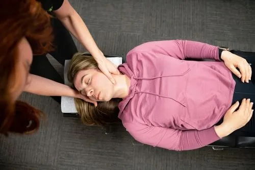 Chiropractor performing a gentle neck adjustment for whiplash on a woman
