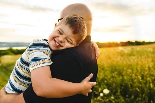 Young boy with autism carry by his father