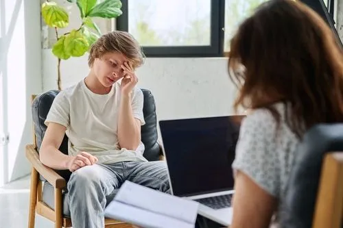 Young man suffering from depression talking to the Therapist