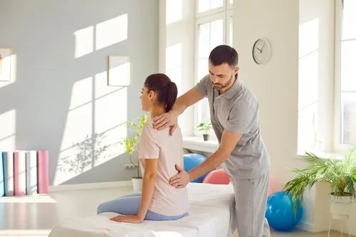 Chiropractor performing back adjustment on patient