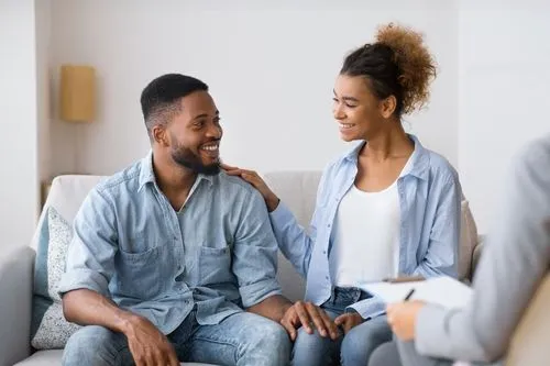 A happy couple participating in a counseling session with a therapist.