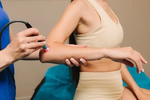 Woman treated with therapeutic laser for elbow discomfort