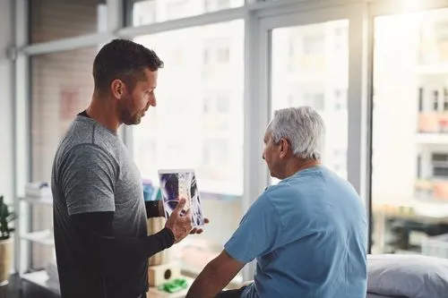 Chiropractor reviewing X-ray results with elderly patient to plan effective treatment.