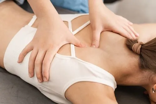 Female client during massage therapy session with chiropractor