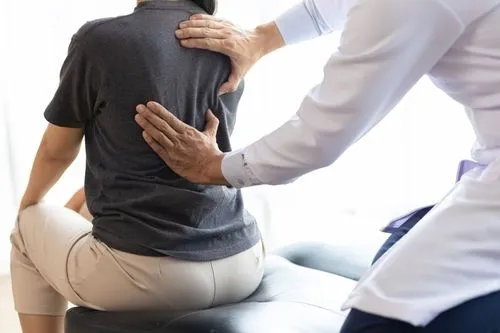 A woman undergoing chiropractic adjustment by a healthcare professional.