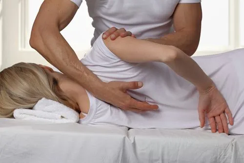 Female client receiving a chiropractic adjustment from a chiropractor