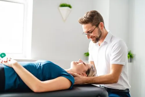 A chiropractor performing a chiropractic session on a female patient.