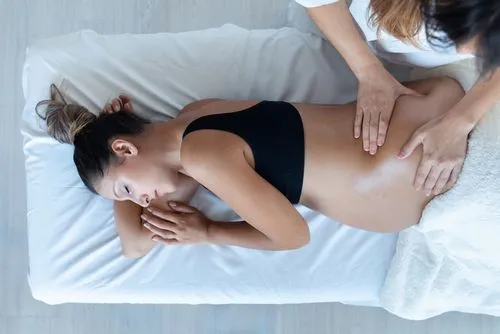 A chiropractor performing a prenatal adjustment on a pregnant patient.