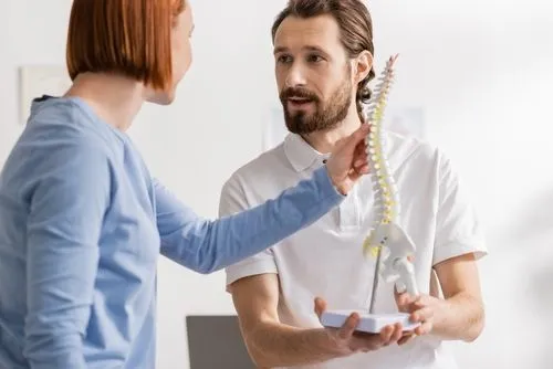 doctor showing spine model to a patient