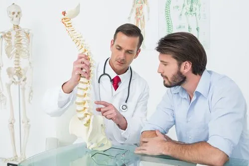 doctor showing spine model to a patient