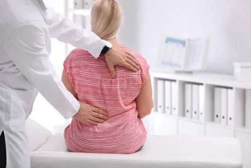Chiropractor helping a female client with back pain