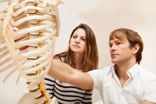 doctor showing spine model to a patient