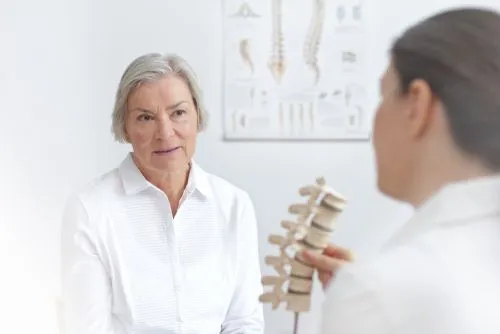 doctor showing spine model to a patient