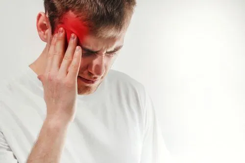 man holding the side of his face from cluster headache pain