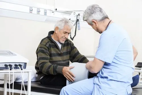 Old Man having PEMF therapy explained to him by a doctor in a medical room